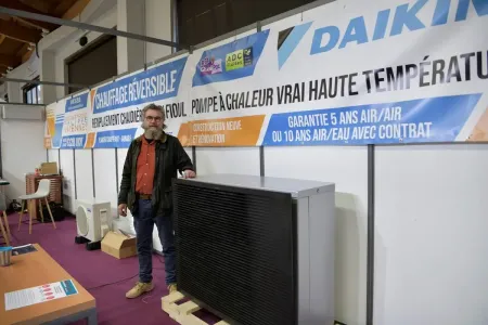 Un homme près d'un pompe à chaleur dans un salon d'expo