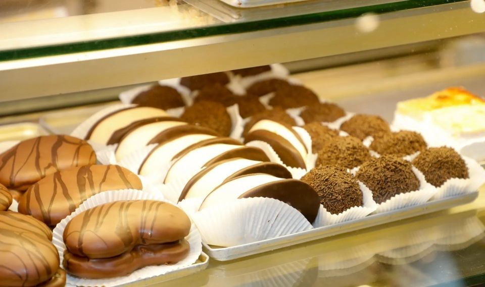 Gebäck in einer Vitrine; mit Schokolade überzogene und mit Sahne gefüllte Süßigkeiten.