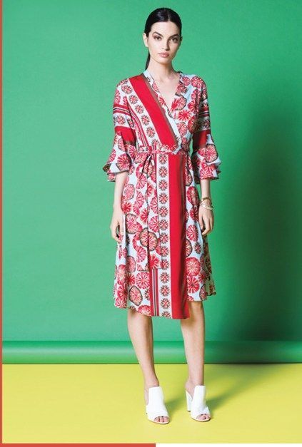 Una mujer lleva un vestido rojo y blanco y zapatos blancos.