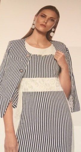 Una mujer lleva un vestido de rayas y una chaqueta.