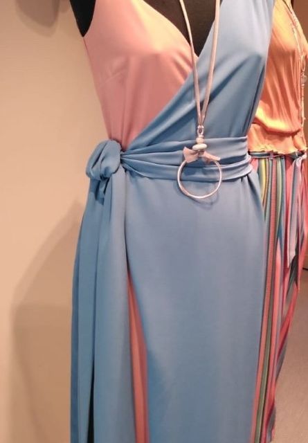 Un vestido rosa y azul está sobre un maniquí.