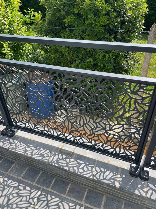 Rambarde de balcon en métal noir à motif de feuilles.