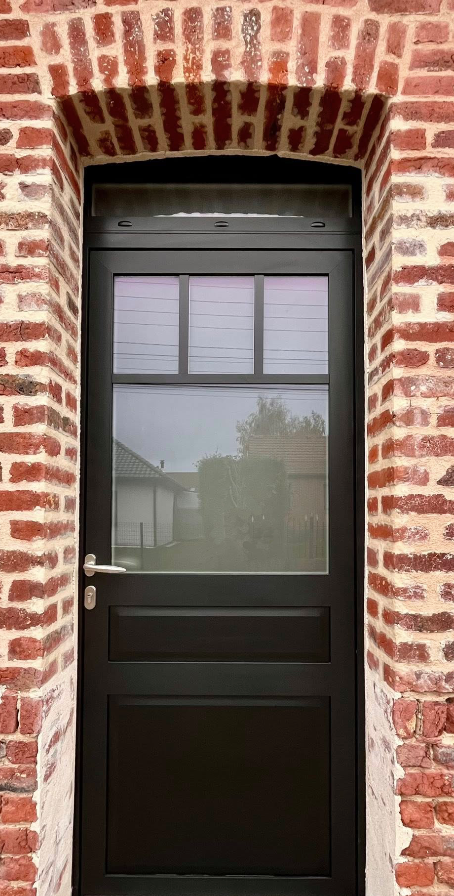 Porte en bois brun avec un panneau rectangulaire, poignée et garniture argentées.