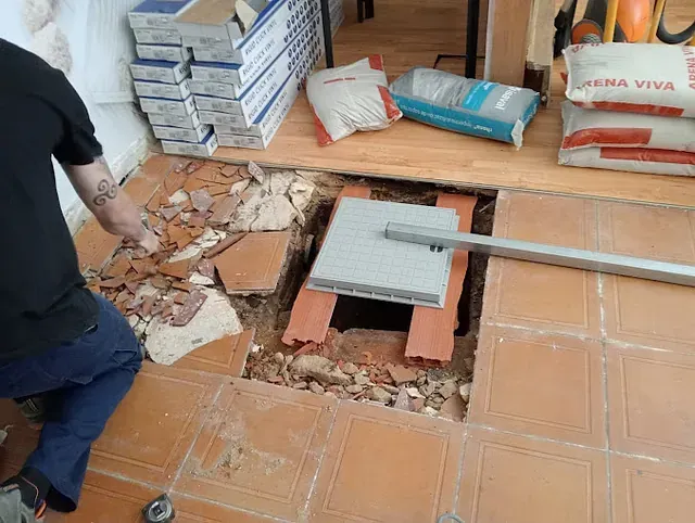 Un hombre está trabajando en un agujero en el suelo.