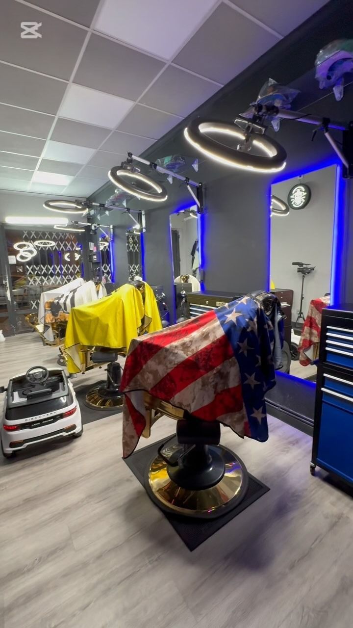 Barbería con capa de bandera estadounidense, detalles dorados e iluminación azul.