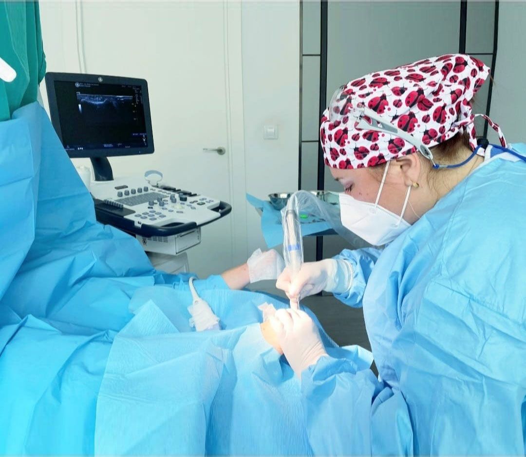 Una cirujana está operando a un paciente en un quirófano.