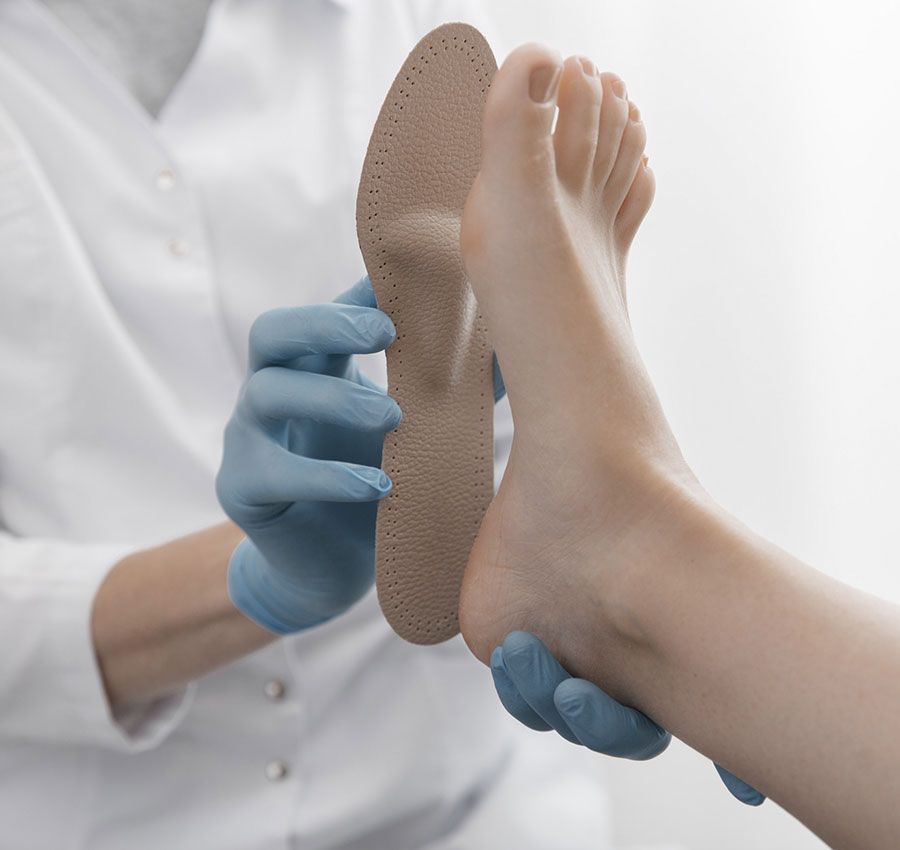 Un médico está examinando el pie de un paciente con una plantilla de zapato.