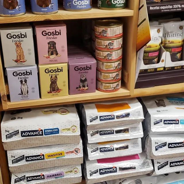 Un estante lleno de muchos tipos diferentes de comida para perros.