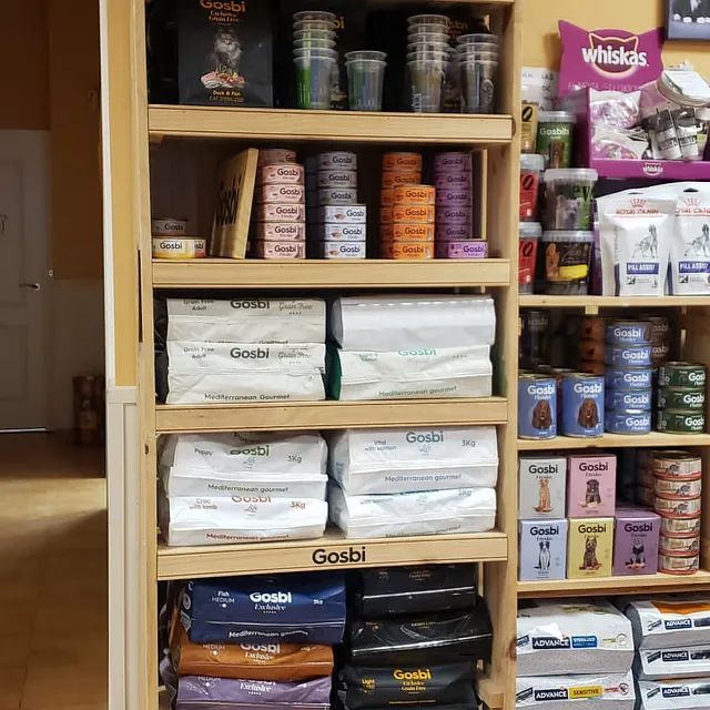 Un estante lleno de comida para perros, incluyendo Gosbi y Whiskas.