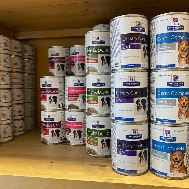 Un estante lleno de latas de comida para perros Hill's Science Diet