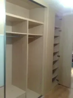 Un armario con muchos estantes y un espejo.