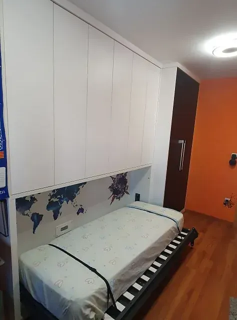 Un dormitorio con una cama y un mapa del mundo en la pared.