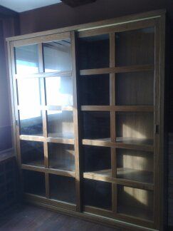 Un armario de madera con puertas corredizas de vidrio en una habitación.