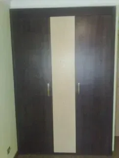 Un armario marrón y blanco con dos puertas en una habitación.