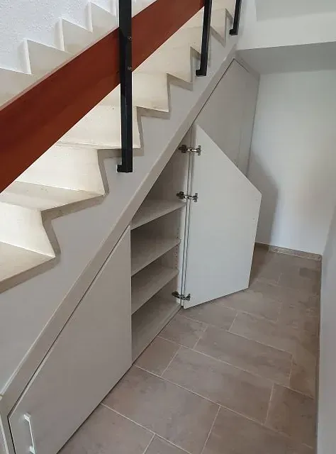 Una escalera con un armario debajo.