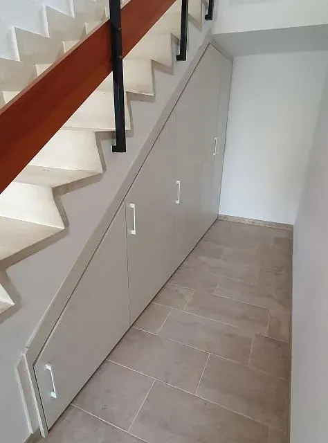 Una escalera con un armario debajo.