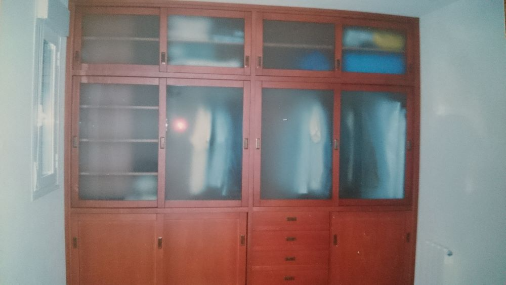 Un gran armario de madera con puertas y cajones de cristal.