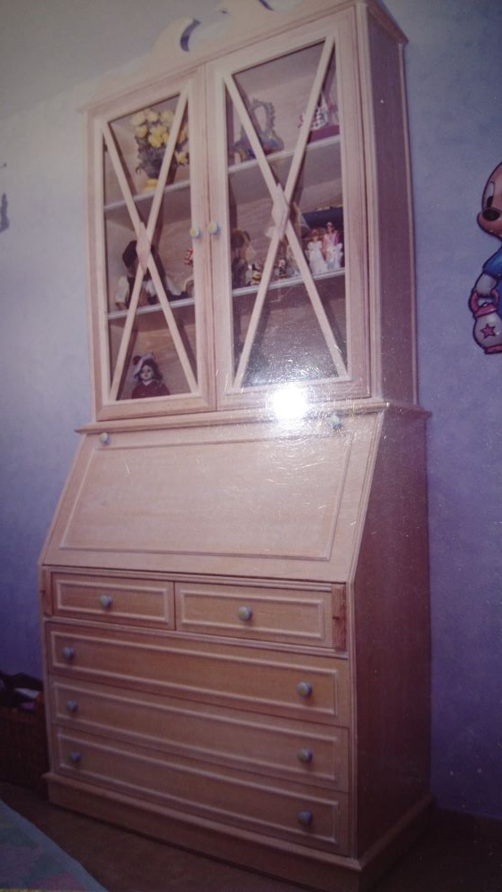 Un armario de madera con cajones y puertas de cristal en una habitación.