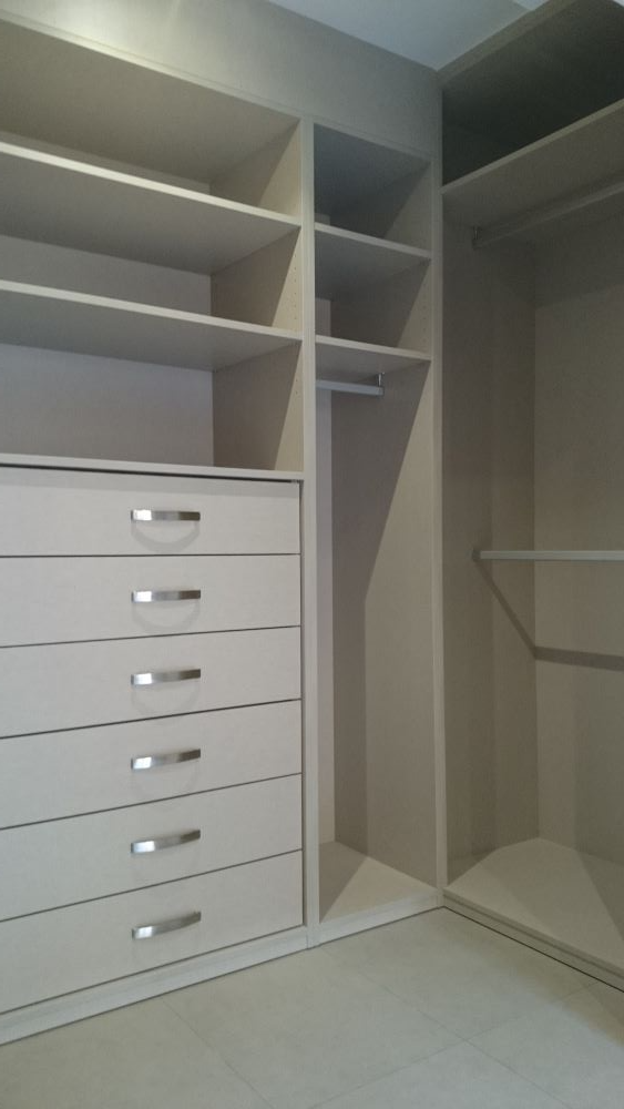 Un vestidor con muchos cajones y estantes.