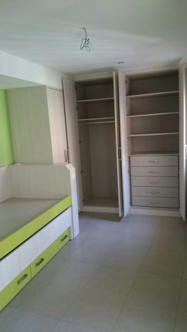 Hay una cama y un armario en la habitación.