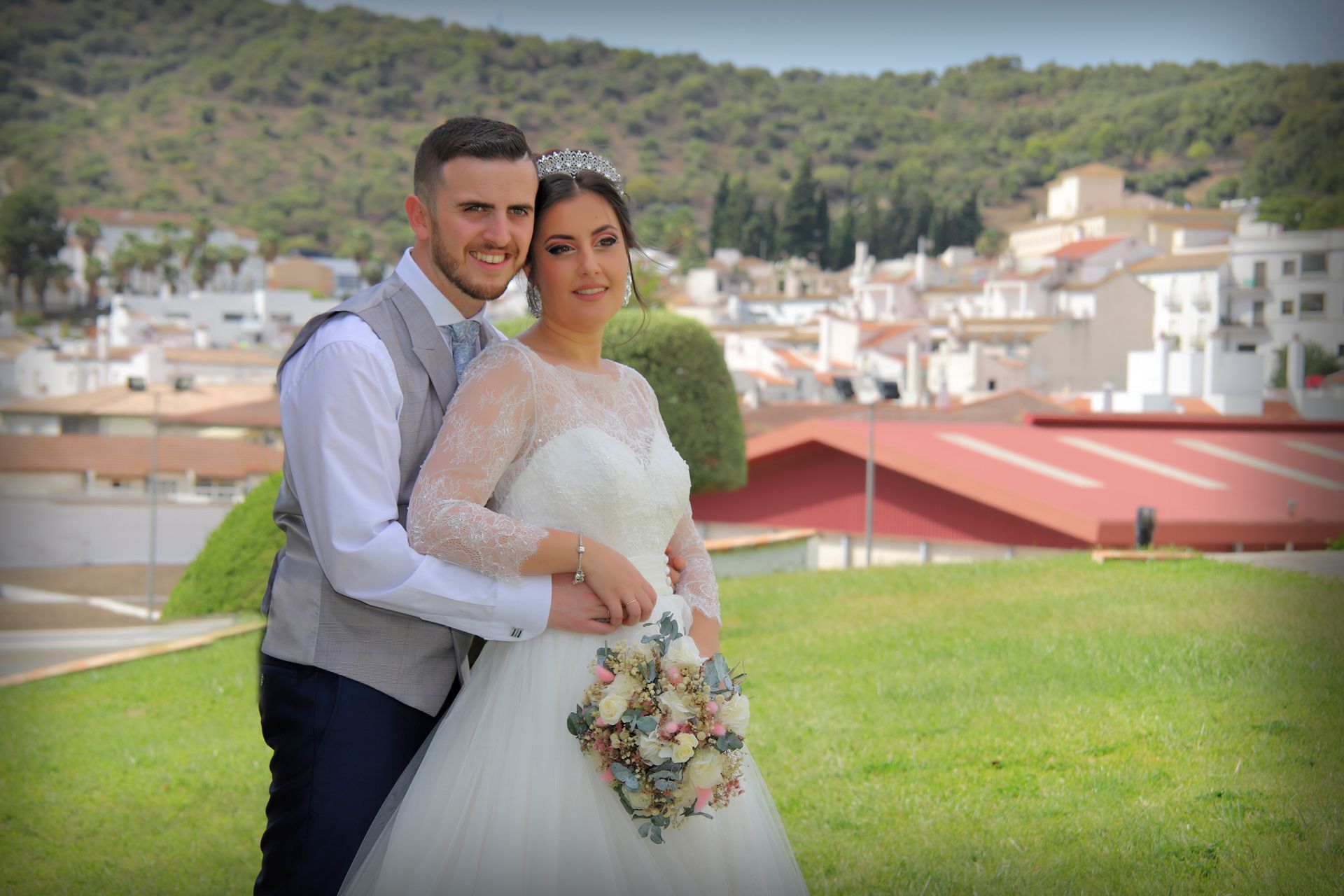Una novia y un novio posan para una fotografía en un campo.