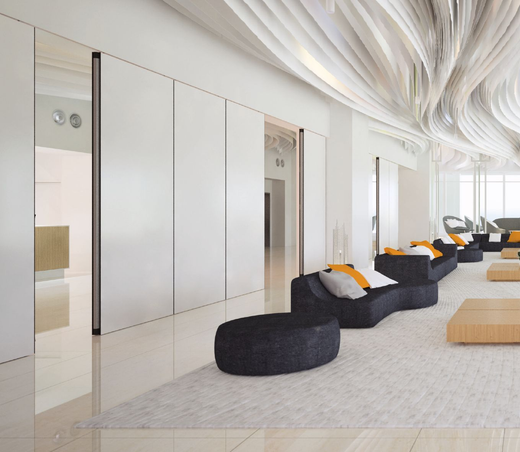 Moderner weißer Warteraum mit schwarzen Sofas, hellen Holztischen und einer geschwungenen, strukturierten Decke.