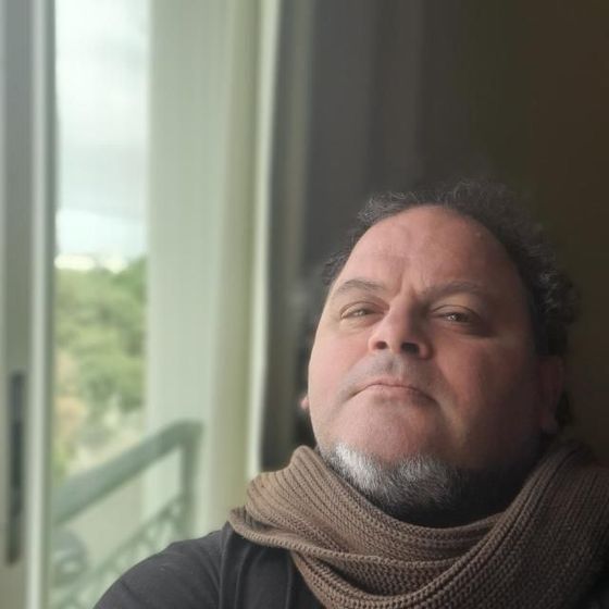 Persona con traje de protección rociando un sistema de pesticida montado en un vehículo sobre arbustos