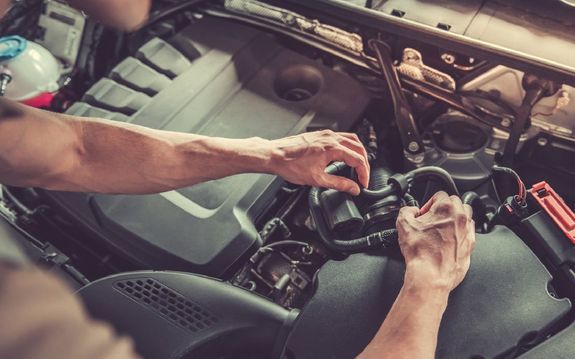 Mies huoltamassa autoa