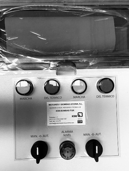 Una fotografía en blanco y negro de un panel de control con botones y perillas.