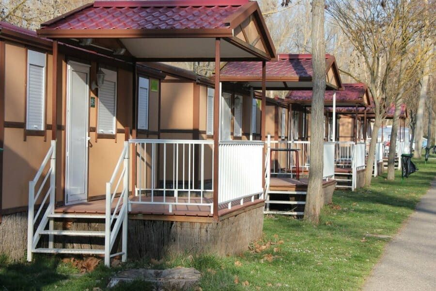 Una hilera de casas pequeñas con porches y escaleras en un parque.