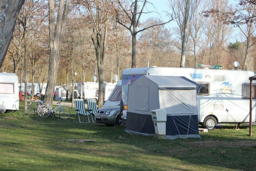 Un grupo de autocaravanas están estacionadas en una zona verde.