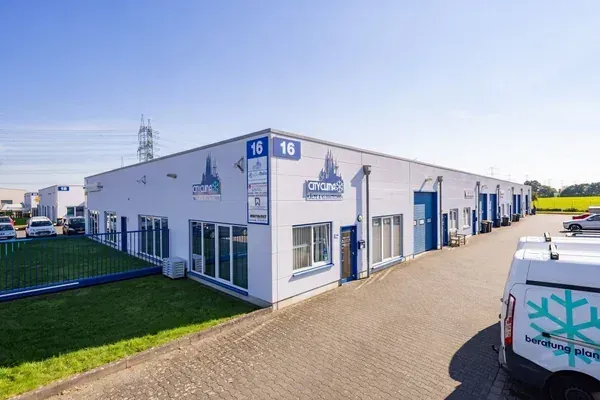Weißes Industriegebäude mit blauen Zierelementen und Schildern