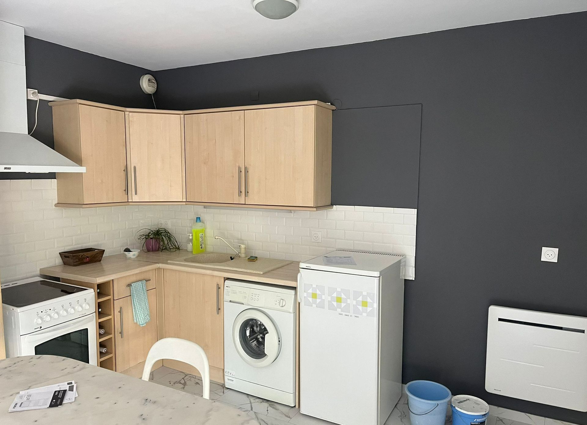 Cuisine aménagée avec pan de mur de peinture grise