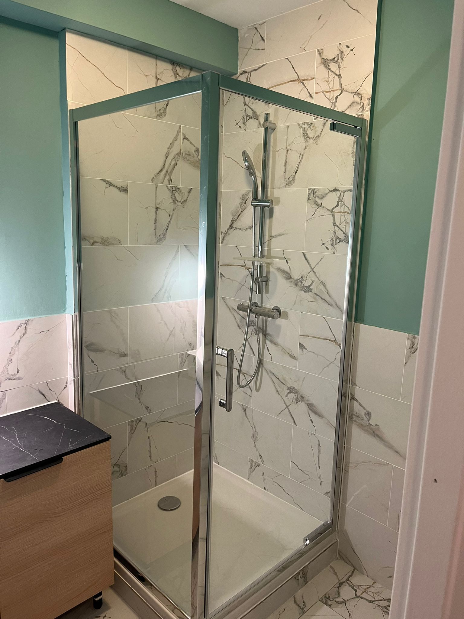 Douche avec parois transparentes et carrelage mural