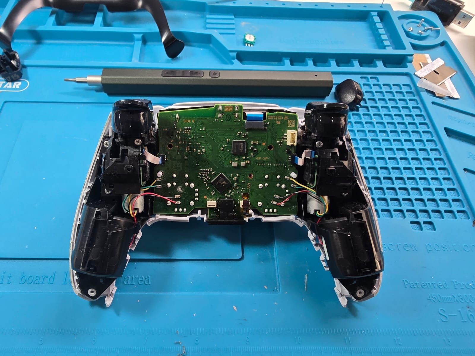 Un controlador de videojuego está sobre una alfombra azul.