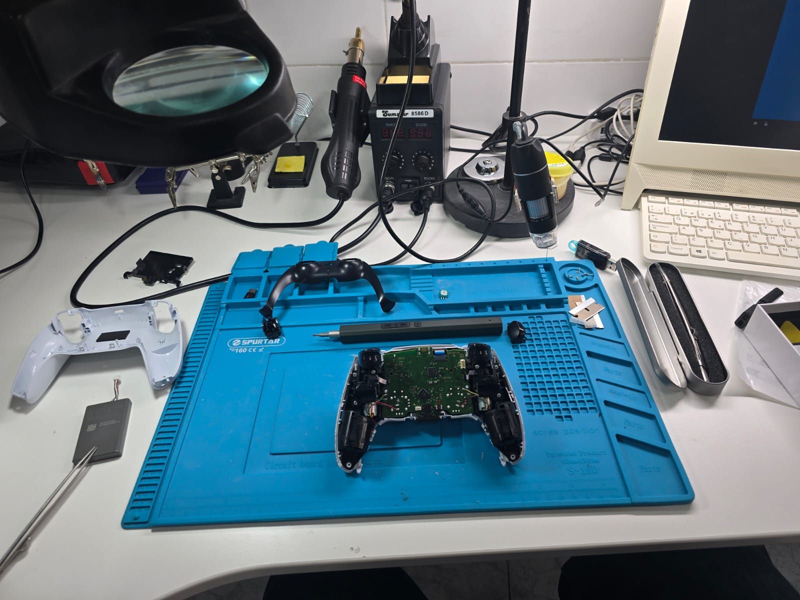 Un controlador de videojuego está sobre una alfombra azul en un escritorio.