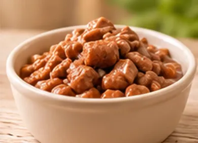 Un tazón de frijoles horneados gruesos en salsa de tomate sobre una mesa de madera.