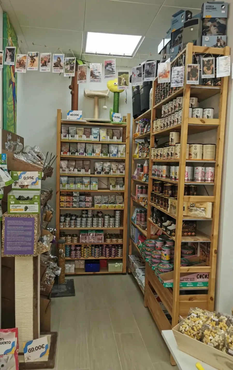 Un estrecho pasillo de tienda repleto de estantes con frascos, botellas y productos envasados
