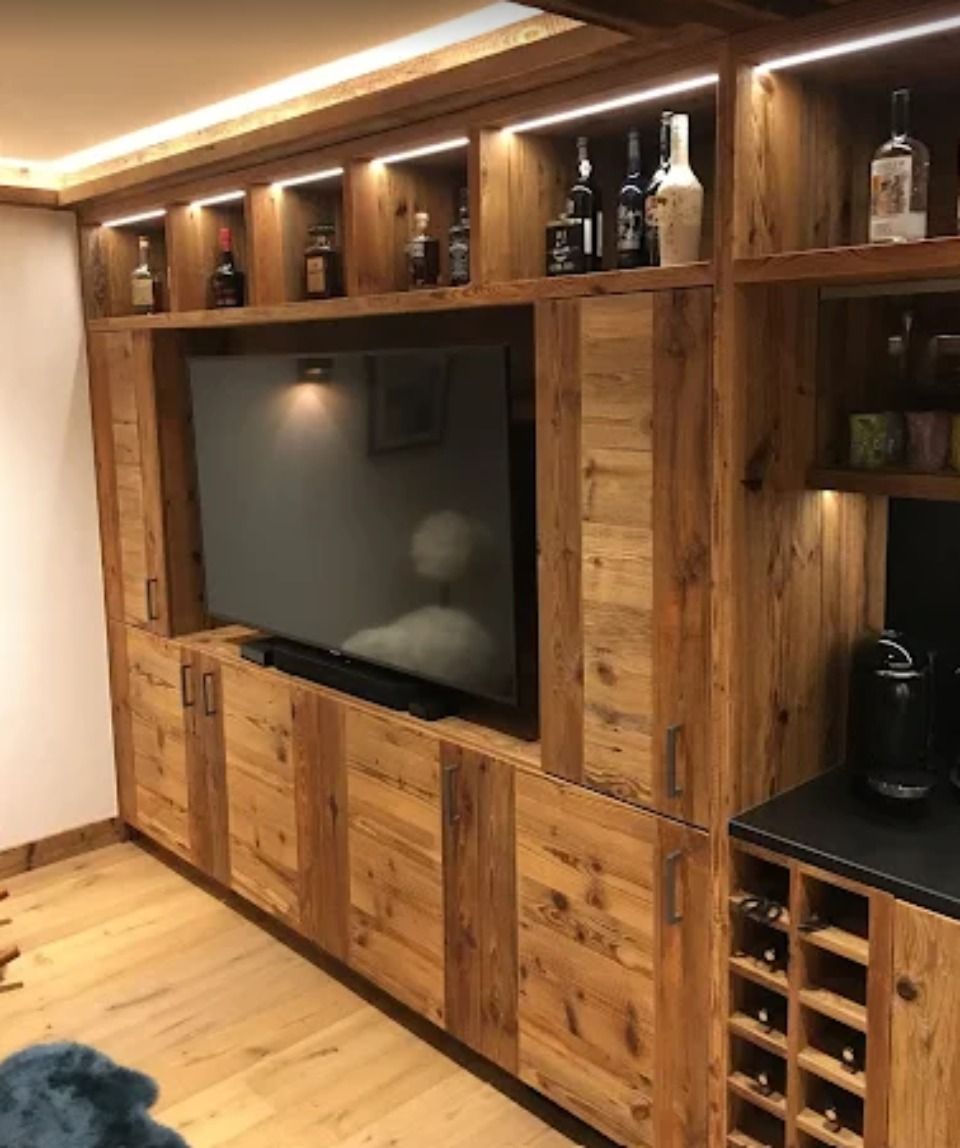 Meuble TV en bois avec télévision, rangement pour bouteilles d'alcool et cave à vin.
