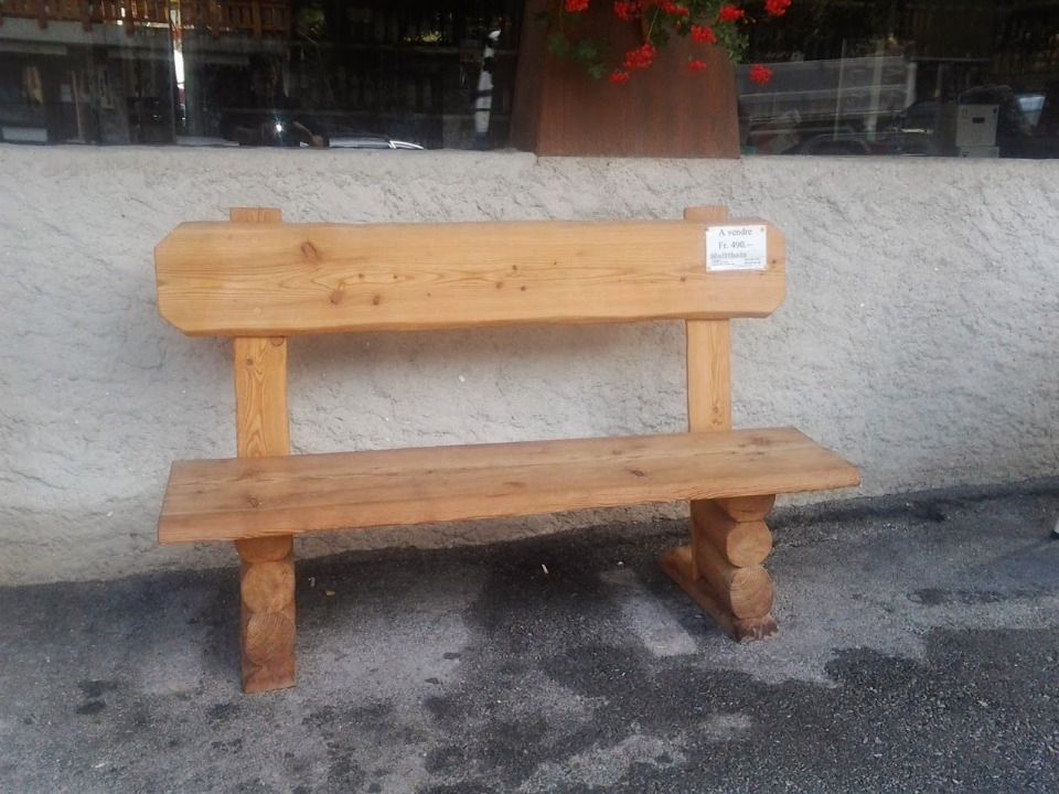 Banc en bois avec dossier, d'extérieur, installé sur une surface en béton.