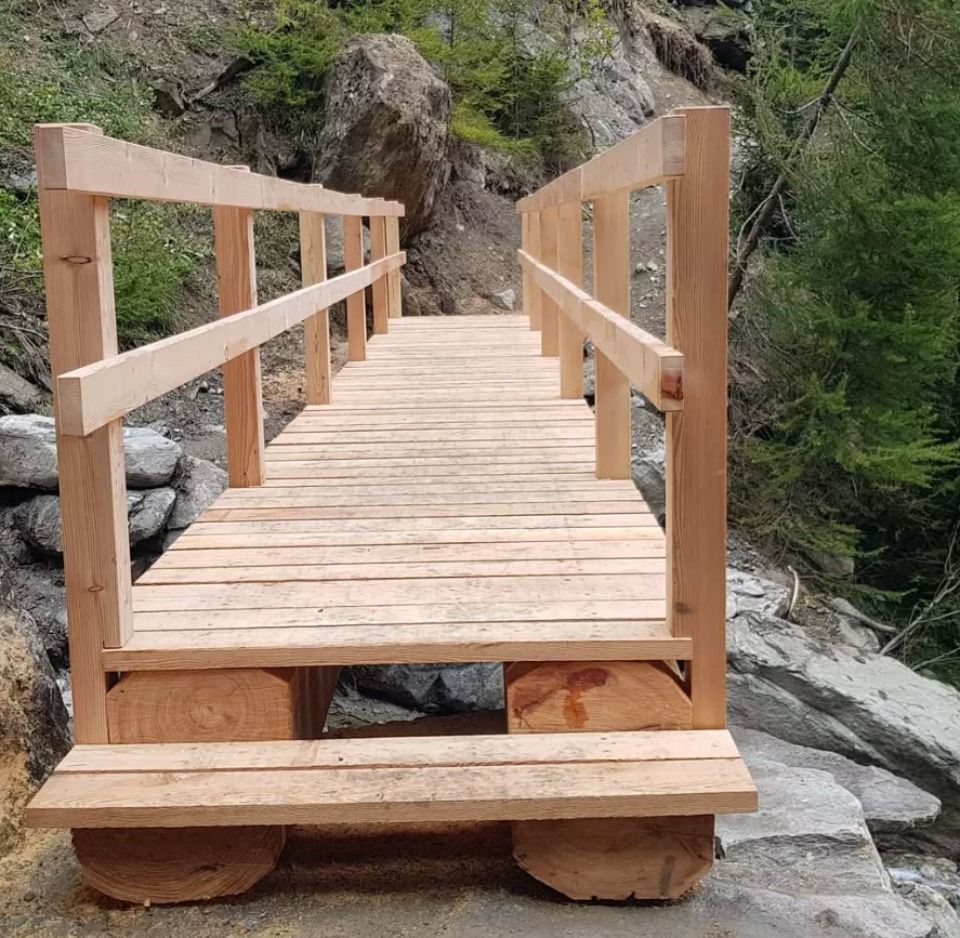 Passerelle en bois avec rambarde au-dessus des rochers.