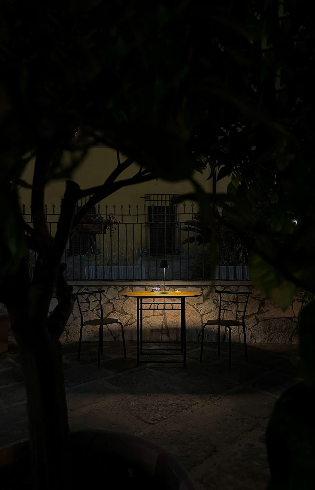 A table and chairs are lit up in the dark
