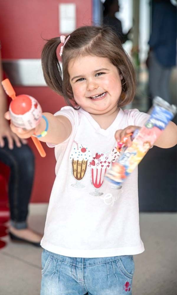 kleines Mädchen hält Gegenstände in die Kamera