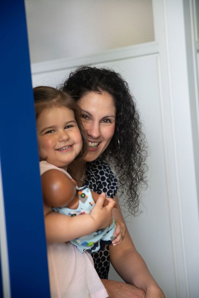 Frau mit Kind, das eine Puppe hält