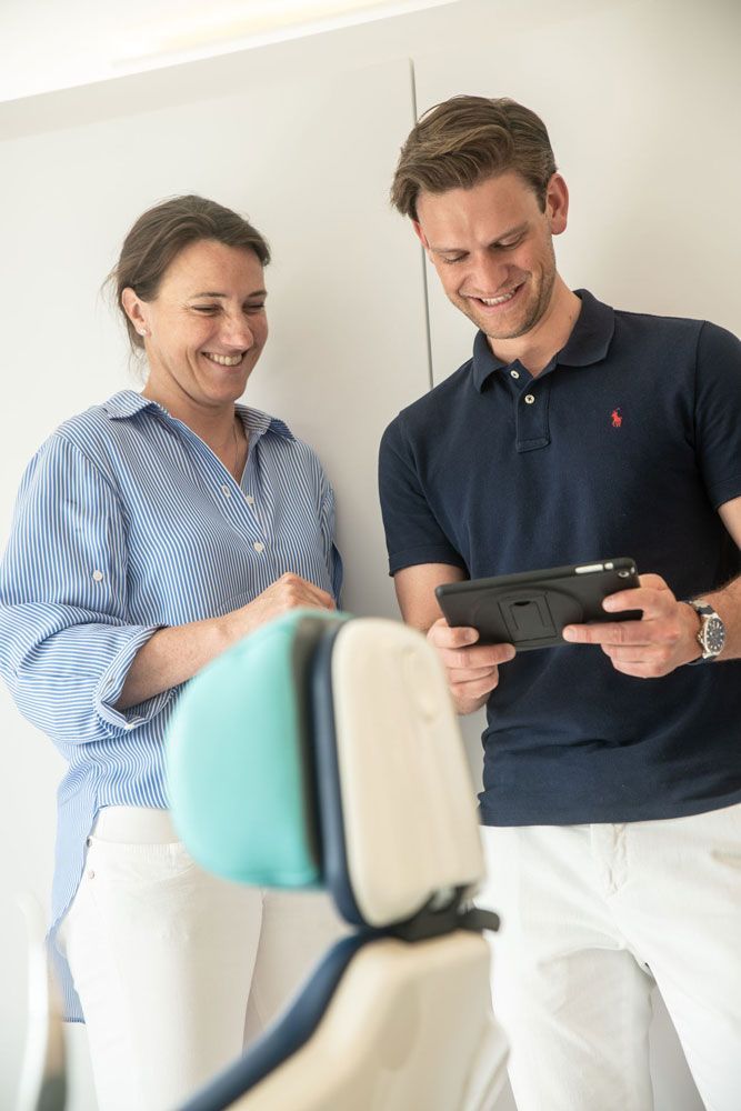 Mitarbeiter von die spangenbauer® – Kieferorthopäde schauen sich etwas auf einem Tablet an