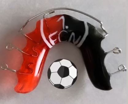schwarz-rote Zahnspange mit Fußball