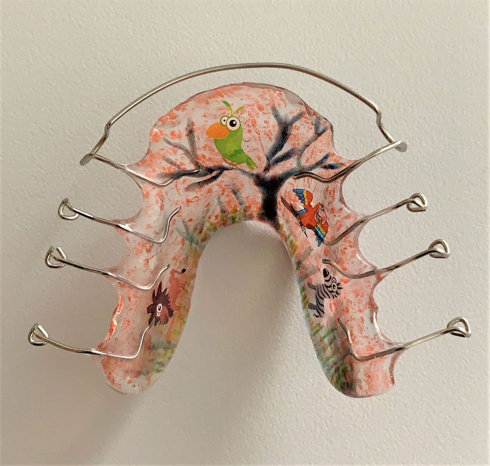 rosafarbene Zahnspange mit Baummotiv