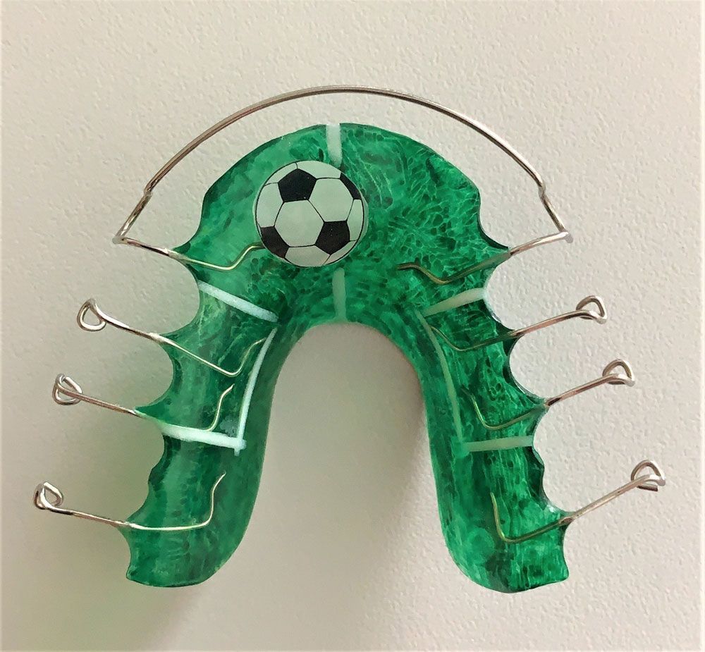grüne Zahnspange mit Fußball