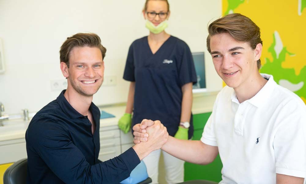 Zahnarzt und Patient schütteln sich die Hände