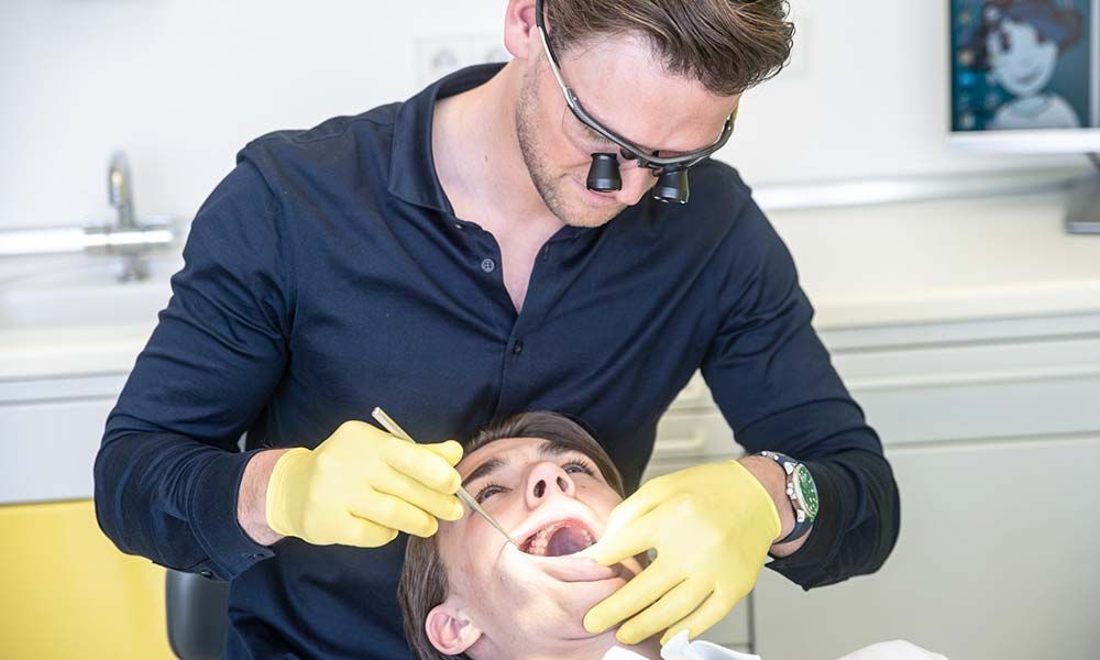 Kieferorthopäde untersucht Patient